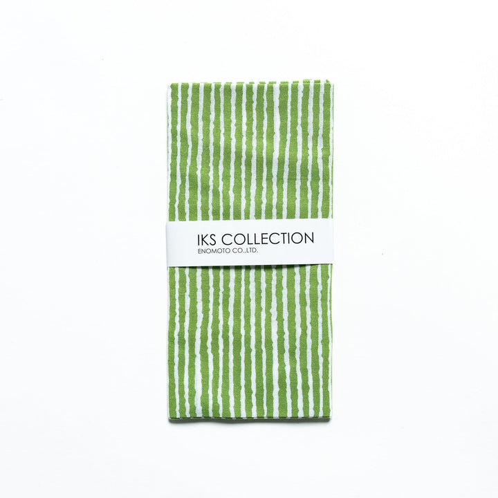 Green hand towel with vertical white stripes, folded with a product sleeve.
