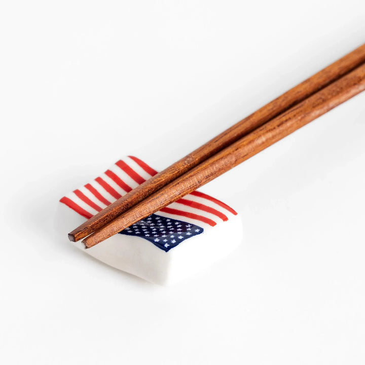 Chopstick rest shaped like the United States flag, featuring red and white stripes with a blue field of white stars.