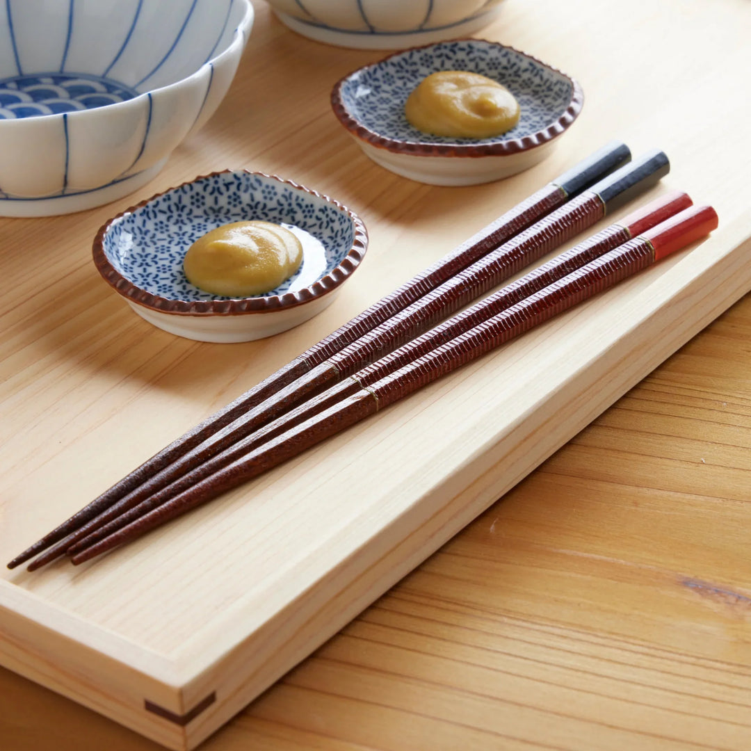 Vermilion and black Urushi line Japanese chopstick set with lacquer finish and textured grip for dining.