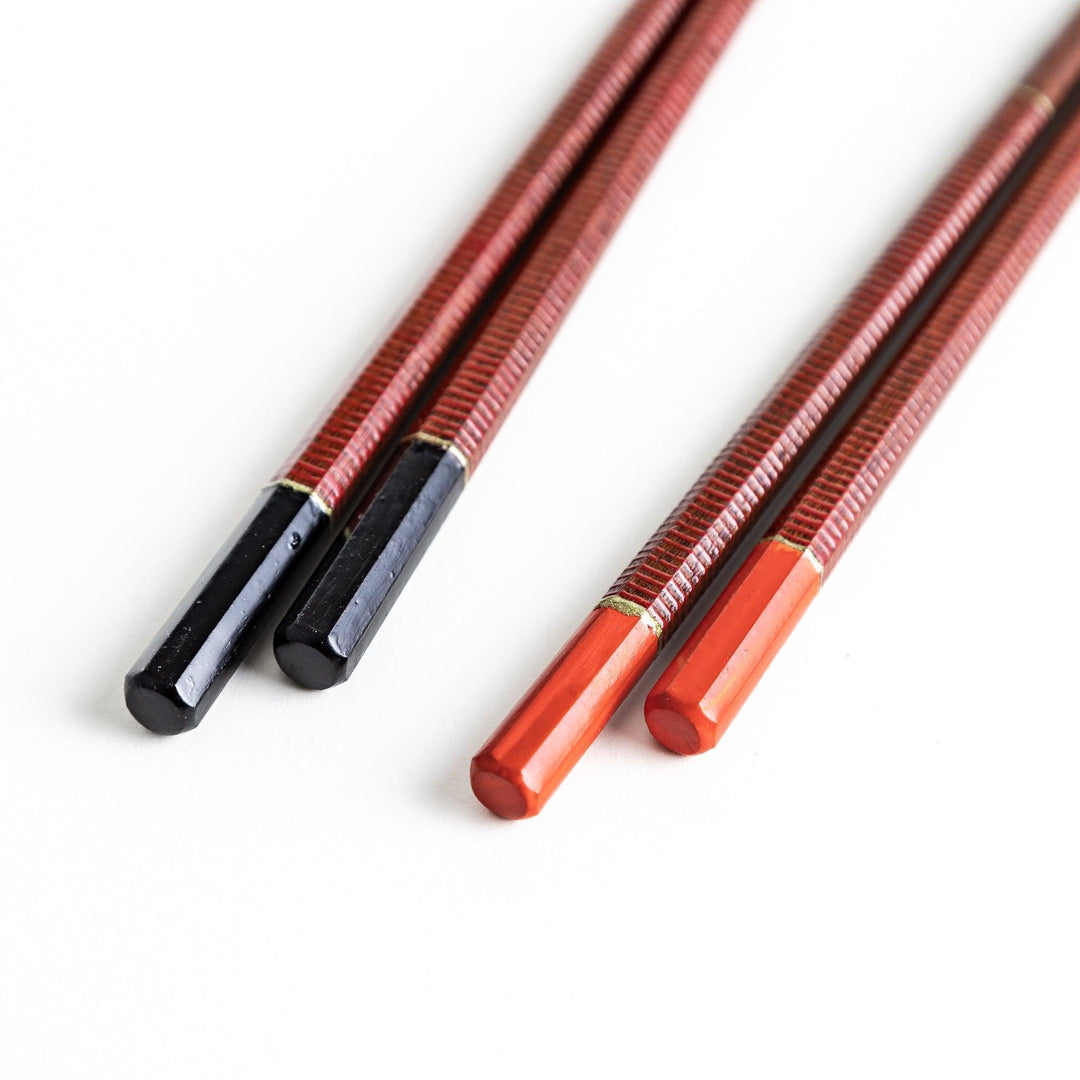 Chopsticks with red and black handles, featuring a rustic and traditional Japanese design.