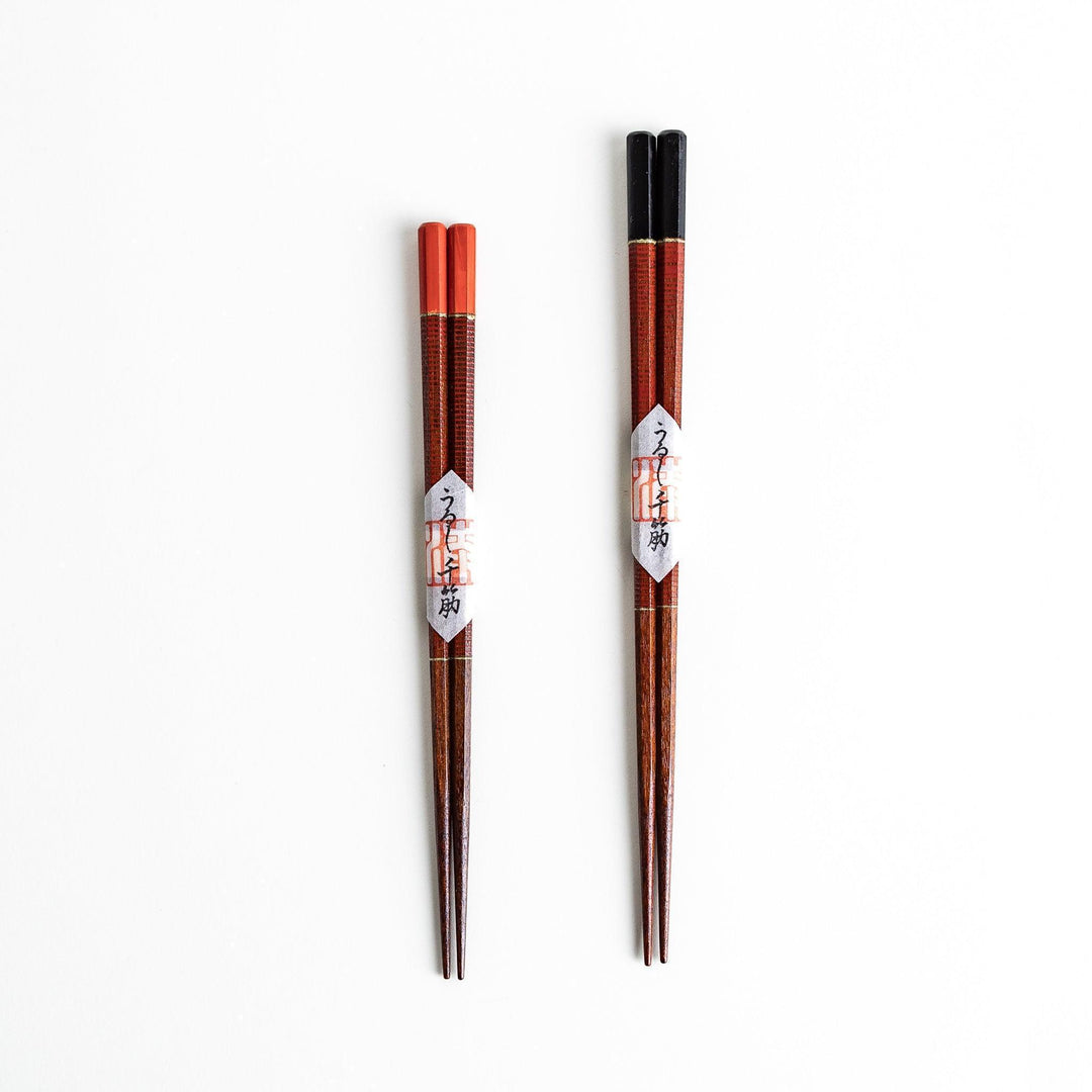Chopsticks with red and black handles, featuring a rustic and traditional Japanese design.