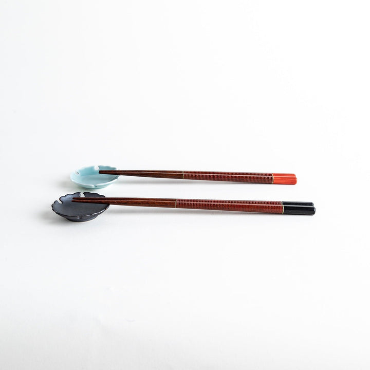 Chopsticks with red and black handles, featuring a rustic and traditional Japanese design.