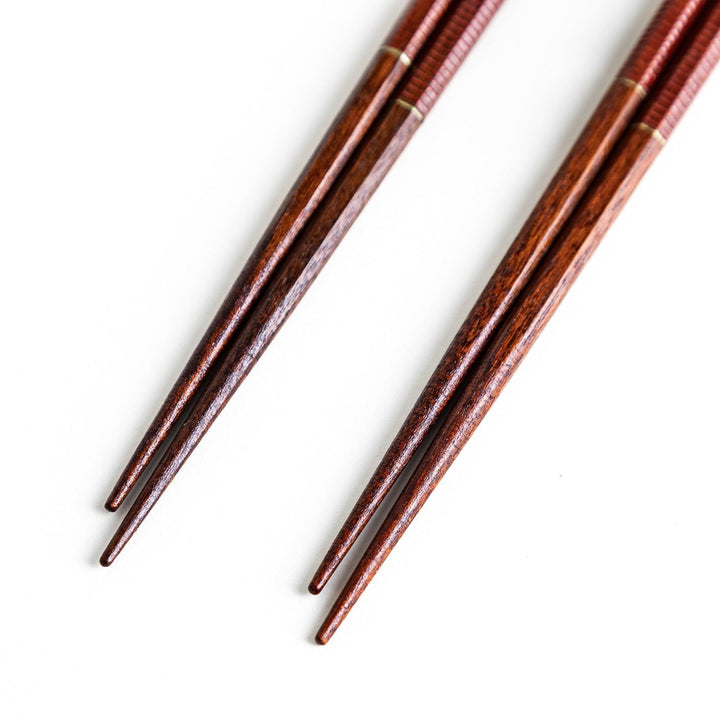 Chopsticks with red and black handles, featuring a rustic and traditional Japanese design.