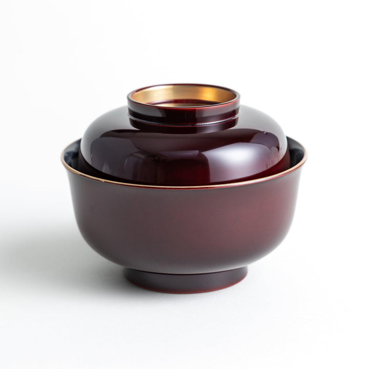 Glossy lacquer soup bowl with matching lid and gold rim available in black or red for elegant serving.