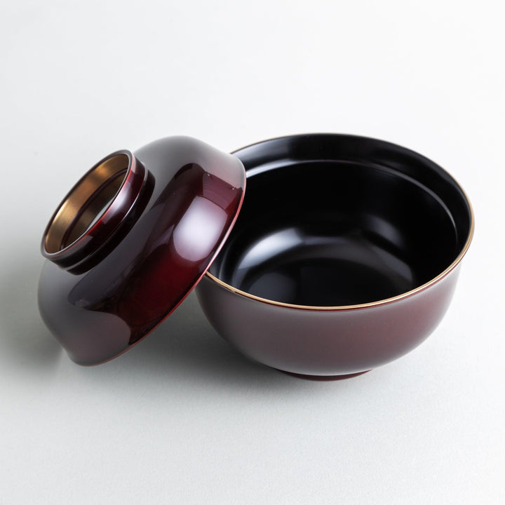 Glossy lacquer soup bowl with matching lid and gold rim available in black or red for elegant serving.