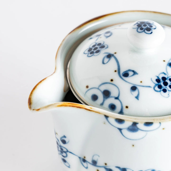 Close-up detail of the teapot's lid and floral design, illustrating the craftsmanship and timeless elegance in every piece.