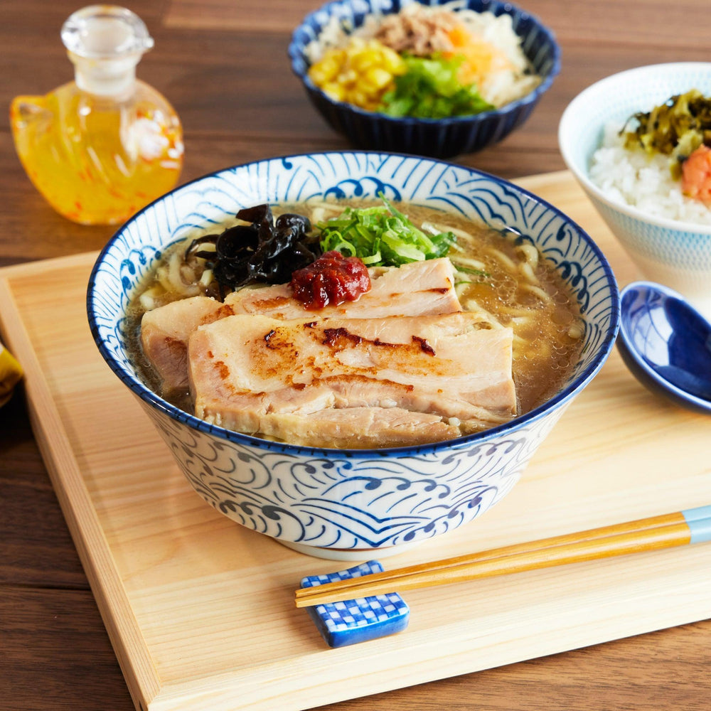 Wave Ripple Ramen Bowl filled with pork ramen, featuring a blue and white swirl pattern and paired with a matching spoon.
