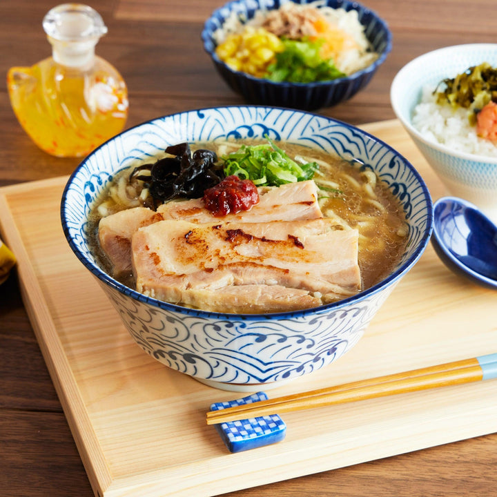 Wave Ripple Ramen Bowl filled with pork ramen, featuring a blue and white swirl pattern and paired with a matching spoon.