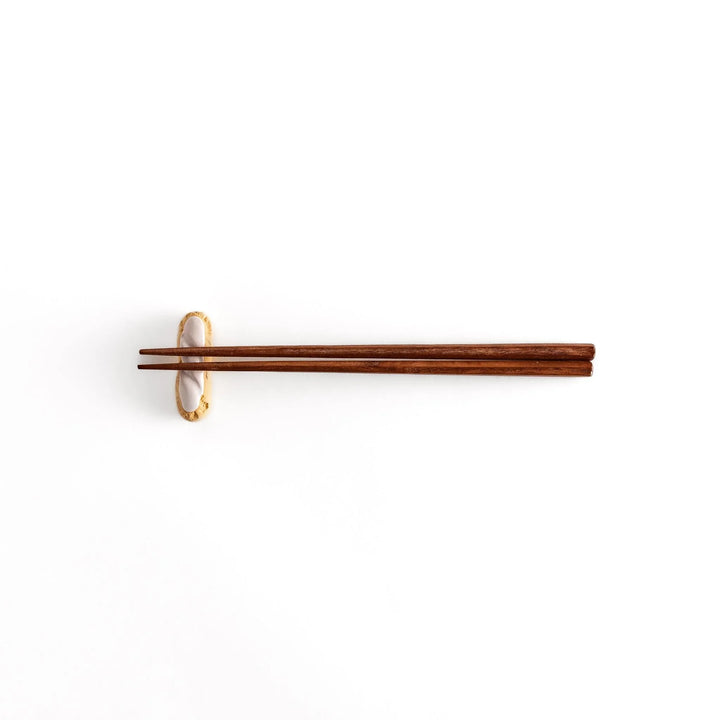 White chocolate éclair chopstick rest with golden brown base and glossy white top for elegant realistic design.