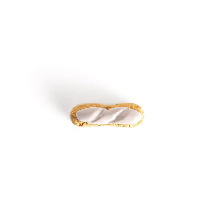 White chocolate éclair chopstick rest with golden brown base and glossy white top for elegant realistic design.