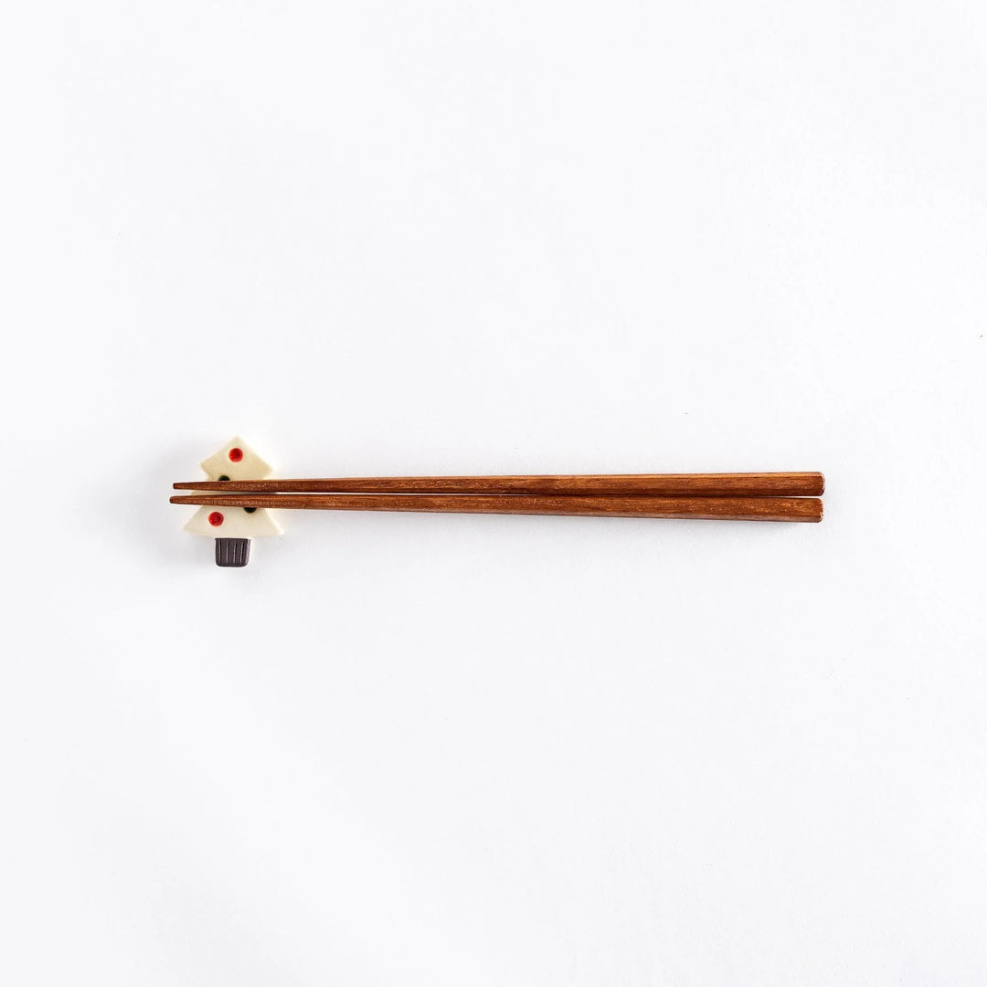 The Christmas tree chopsticks rest with chopsticks on top, photographed from a distance.