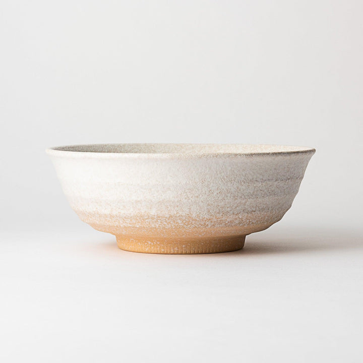A bowl with a textured, speckled white glaze and a natural, earthy appearance.