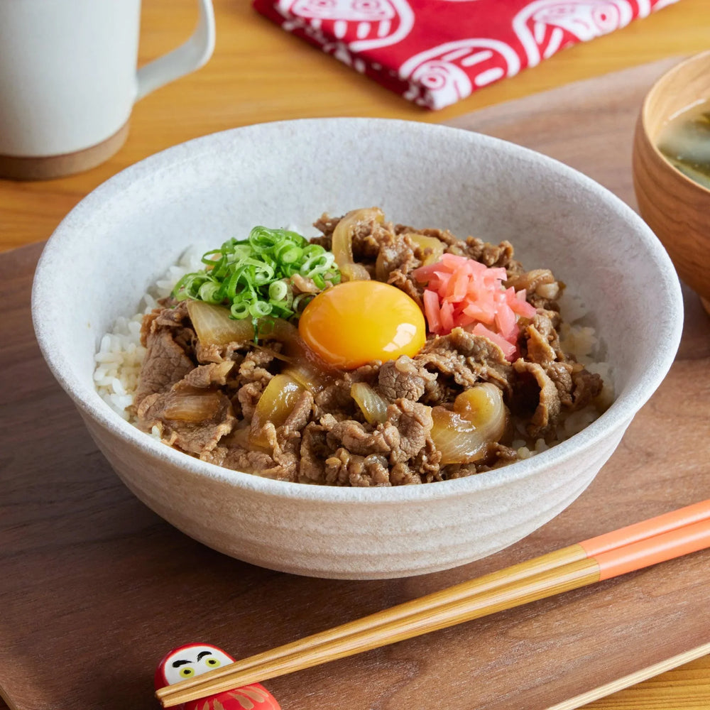 White Dew Donburi Bowl with gyudon beef onion egg and rice served with miso soup and chopsticks.