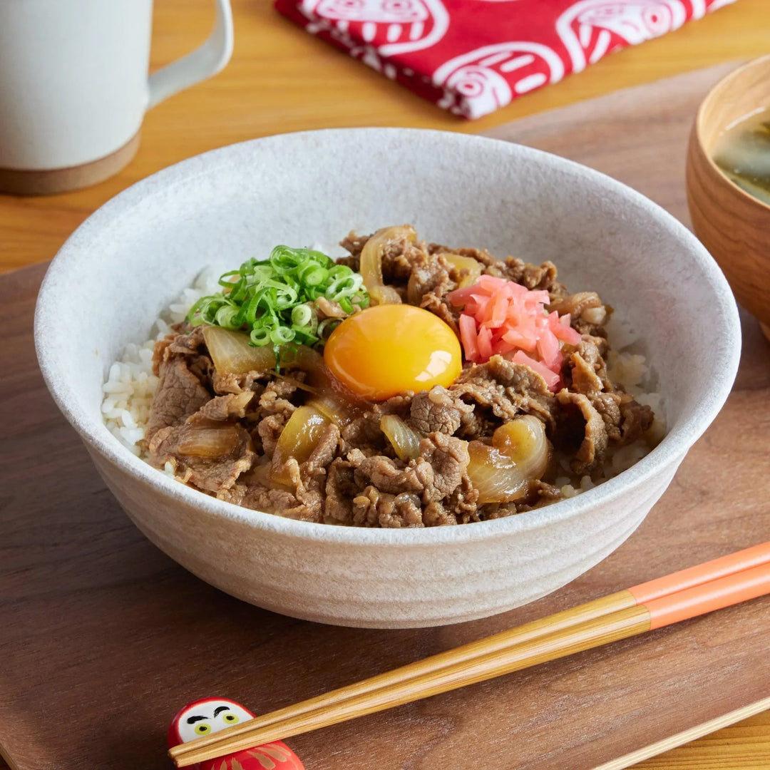 White Dew Donburi Bowl with gyudon beef onion egg and rice served with miso soup and chopsticks.
