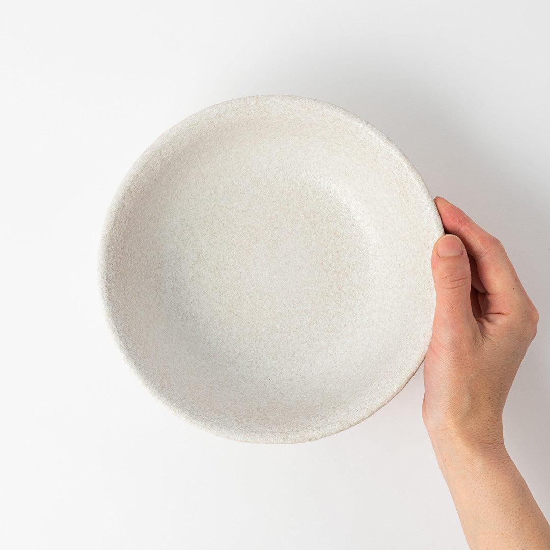 A bowl with a textured, speckled white glaze and a natural, earthy appearance.