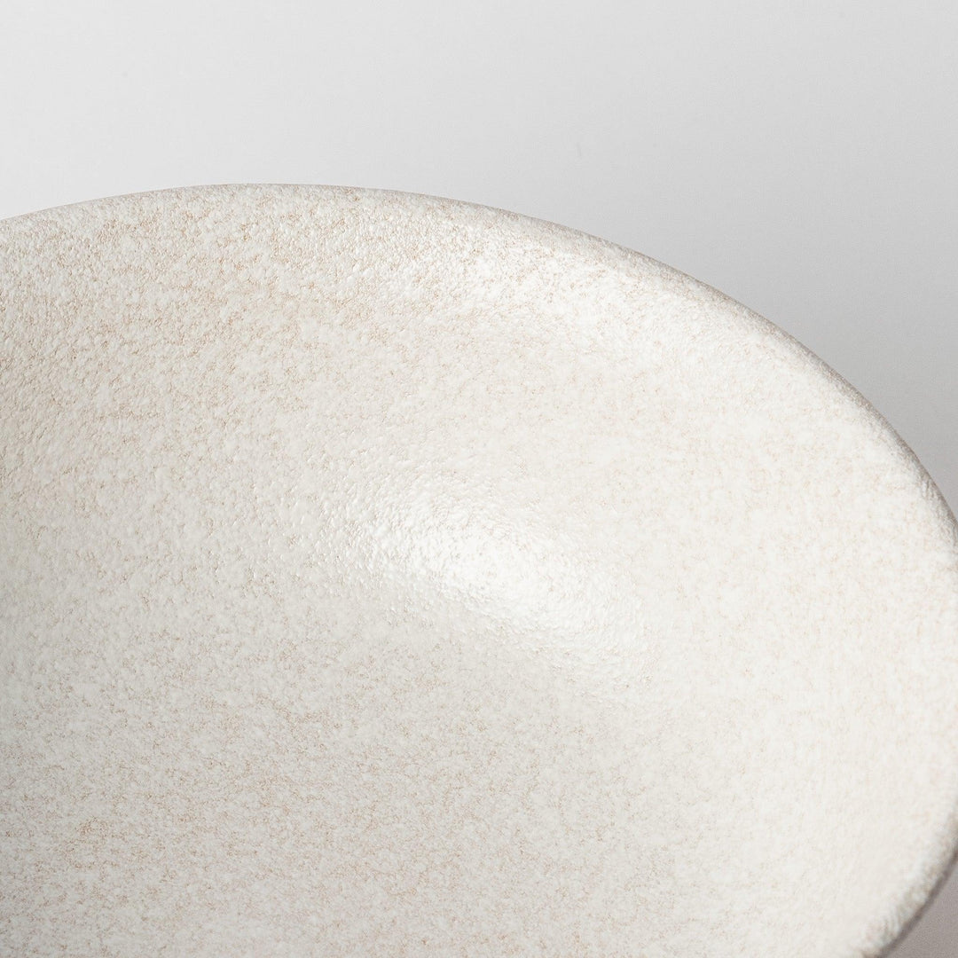 A bowl with a textured, speckled white glaze and a natural, earthy appearance.