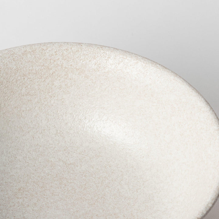 A bowl with a textured, speckled white glaze and a natural, earthy appearance.