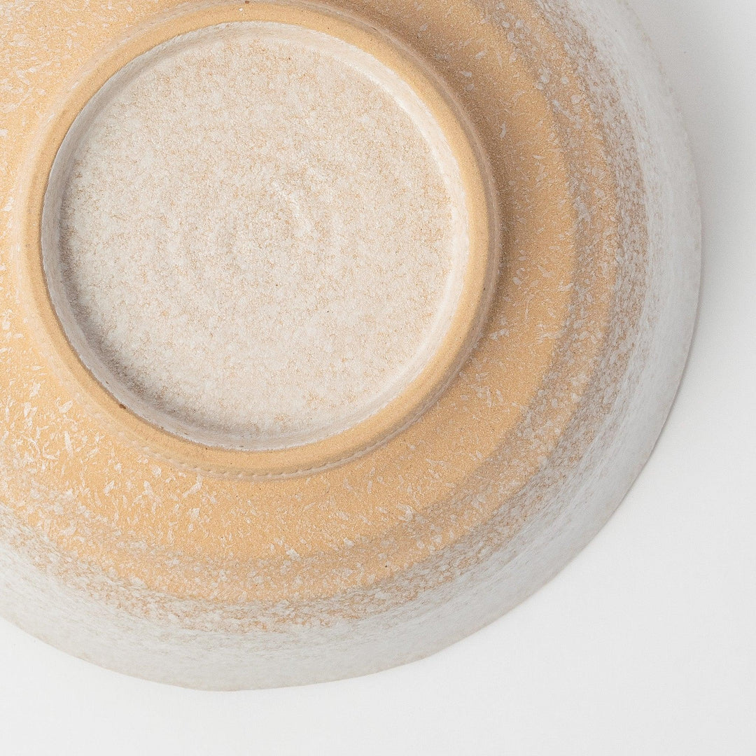 A bowl with a textured, speckled white glaze and a natural, earthy appearance.