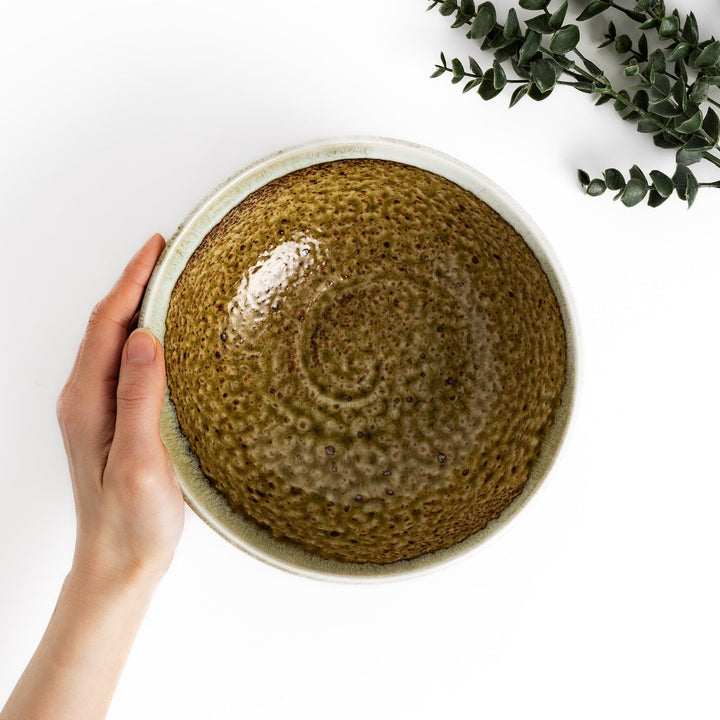 Ramen bowl featuring a beautiful white drip glaze over an earthy, textured base, combining natural tones of brown and green.