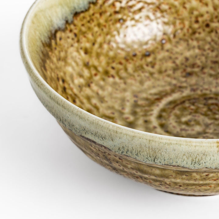 Ramen bowl featuring a beautiful white drip glaze over an earthy, textured base, combining natural tones of brown and green.