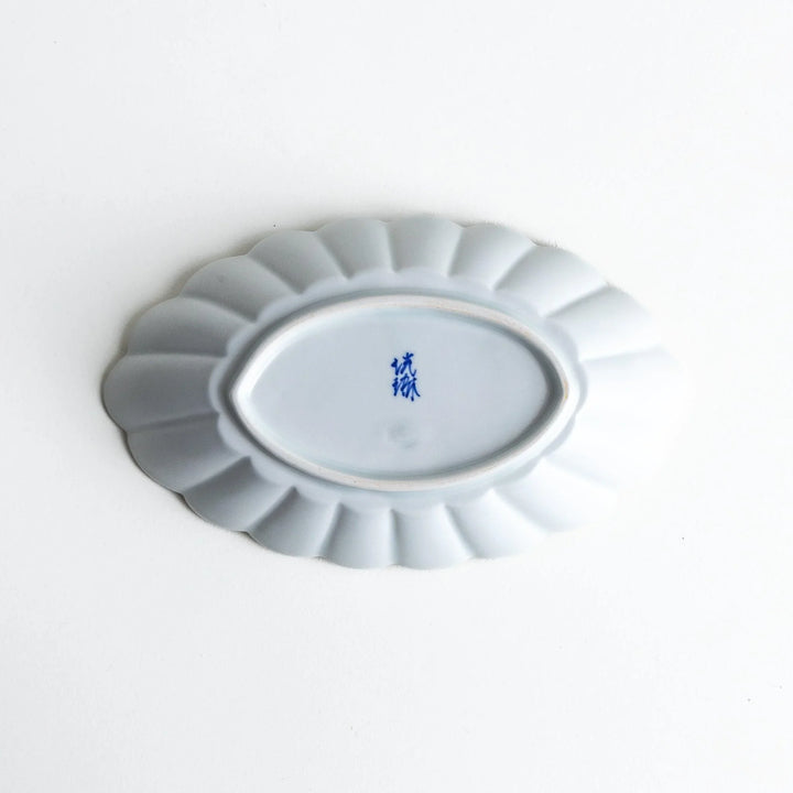 A white porcelain oval pasta bowl with a scalloped design.