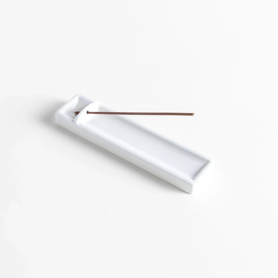 Minimalist white ceramic Japanese incense holder with rectangular shape and slot for clean ash catching.