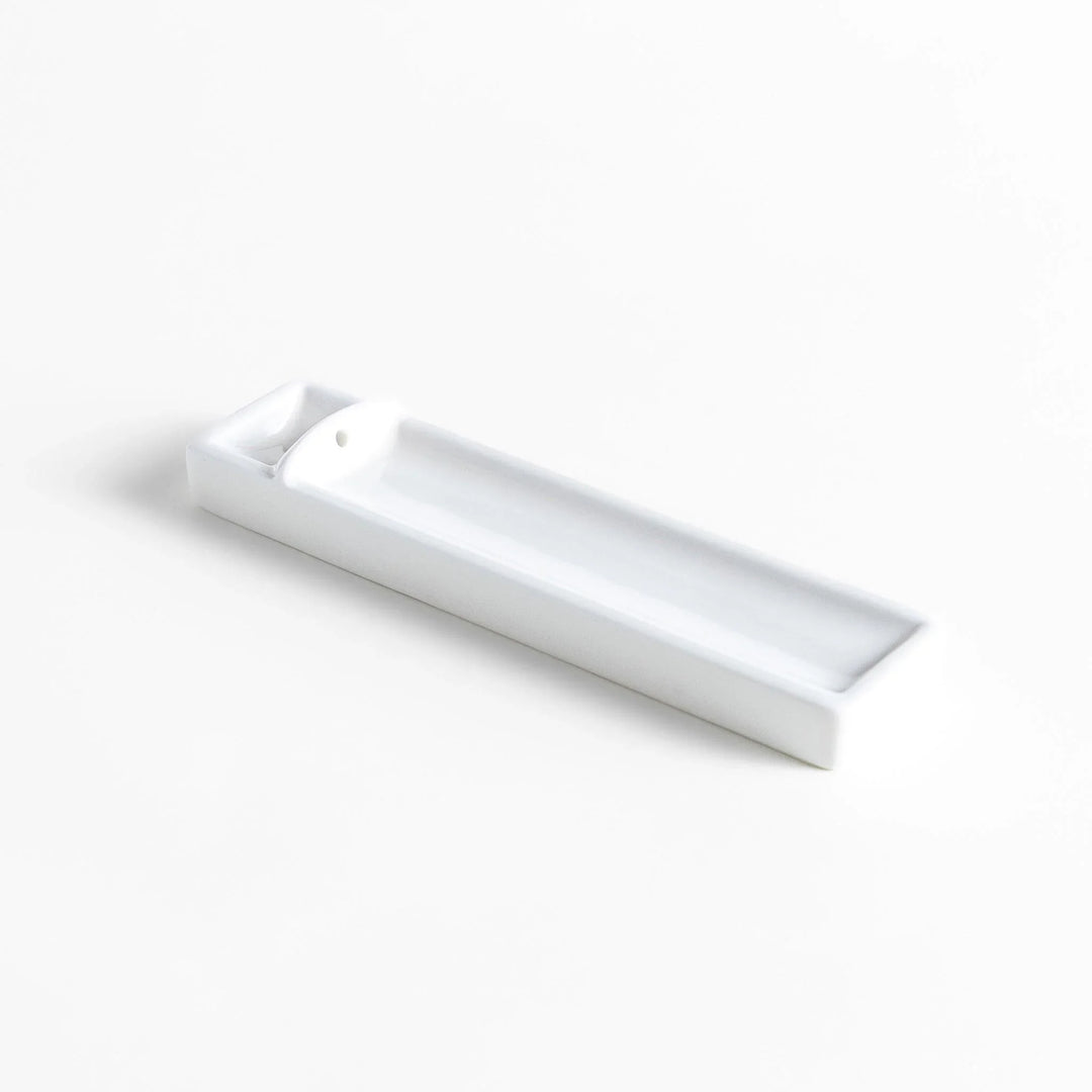 Minimalist white ceramic Japanese incense holder with rectangular shape and slot for clean ash catching.