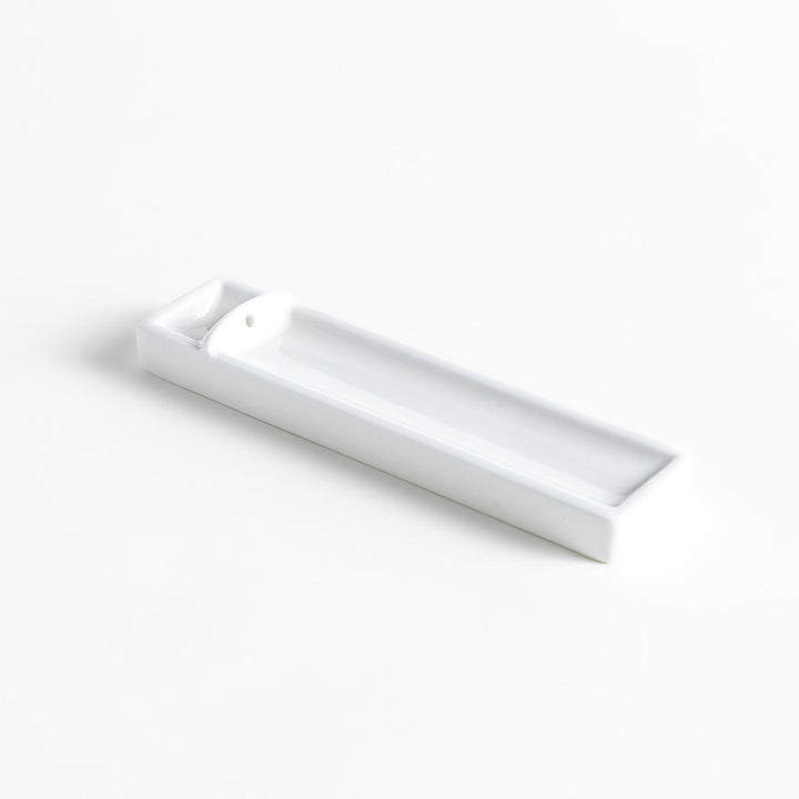 Minimalist white ceramic Japanese incense holder with rectangular shape and slot for clean ash catching.