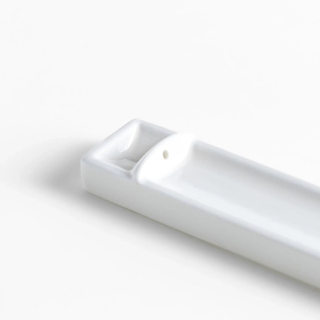 Minimalist white ceramic Japanese incense holder with rectangular shape and slot for clean ash catching.