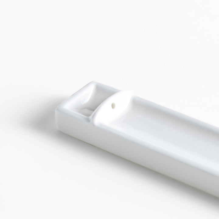 Minimalist white ceramic Japanese incense holder with rectangular shape and slot for clean ash catching.