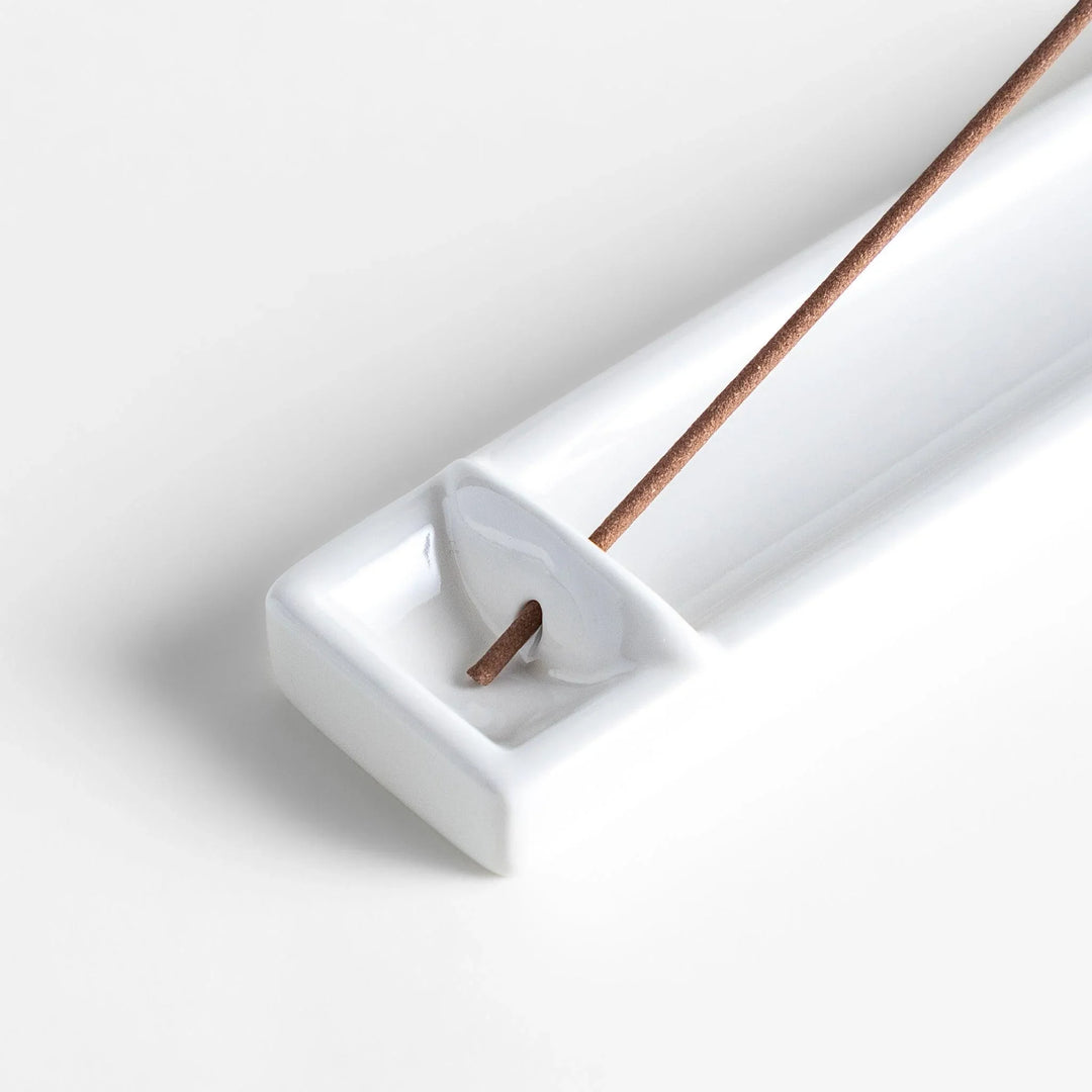 Minimalist white ceramic Japanese incense holder with rectangular shape and slot for clean ash catching.