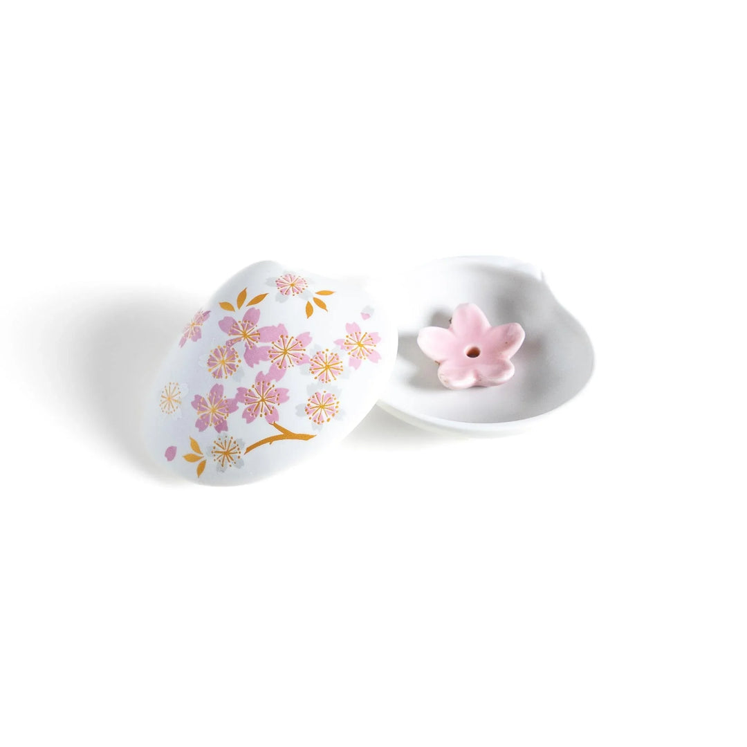 White seashell-shaped incense holder with pink and gold sakura details and blossom stand for a refined touch.