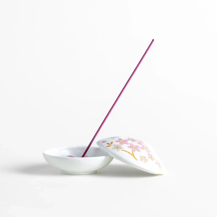 White seashell-shaped incense holder with pink and gold sakura details and blossom stand for a refined touch.