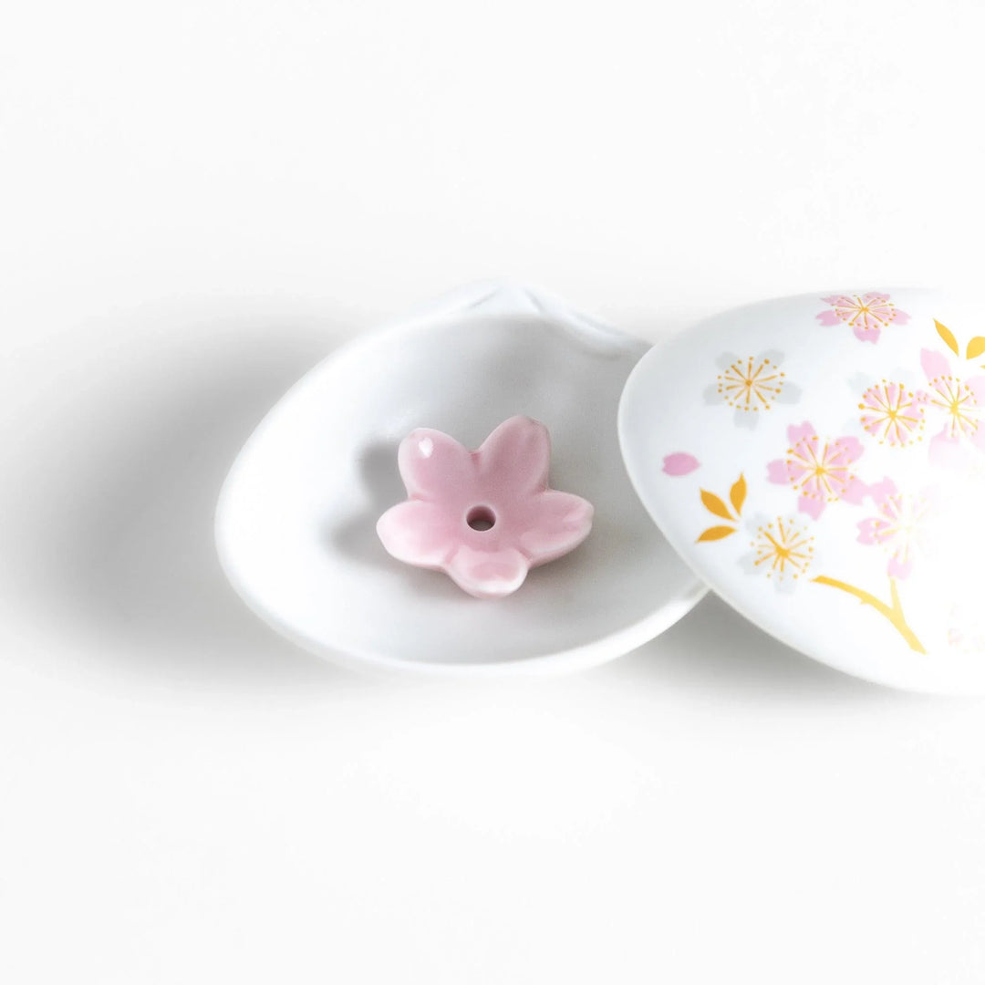 White seashell-shaped incense holder with pink and gold sakura details and blossom stand for a refined touch.