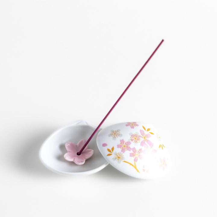 White seashell-shaped incense holder with pink and gold sakura details and blossom stand for a refined touch.