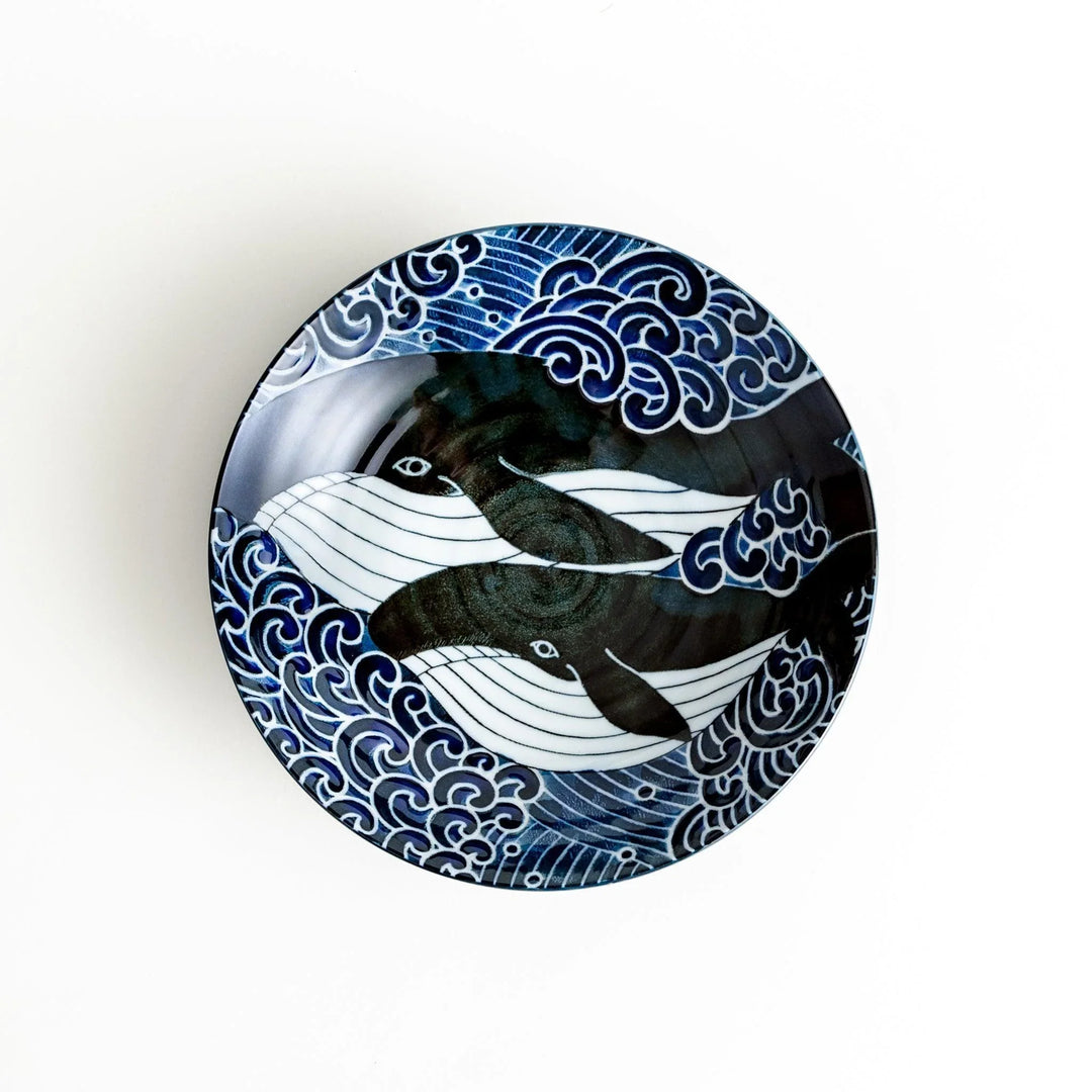 A pasta bowl decorated with blue and white whales and waves.