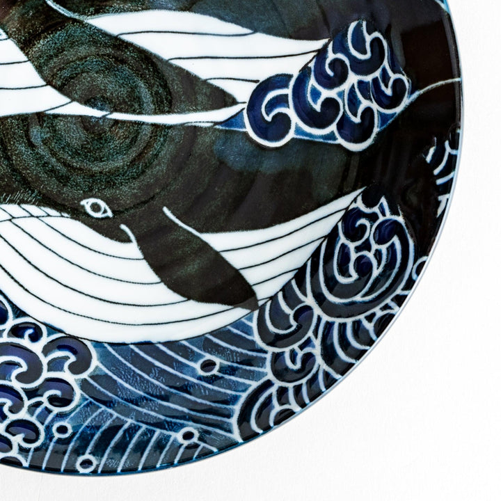 A pasta bowl decorated with blue and white whales and waves.
