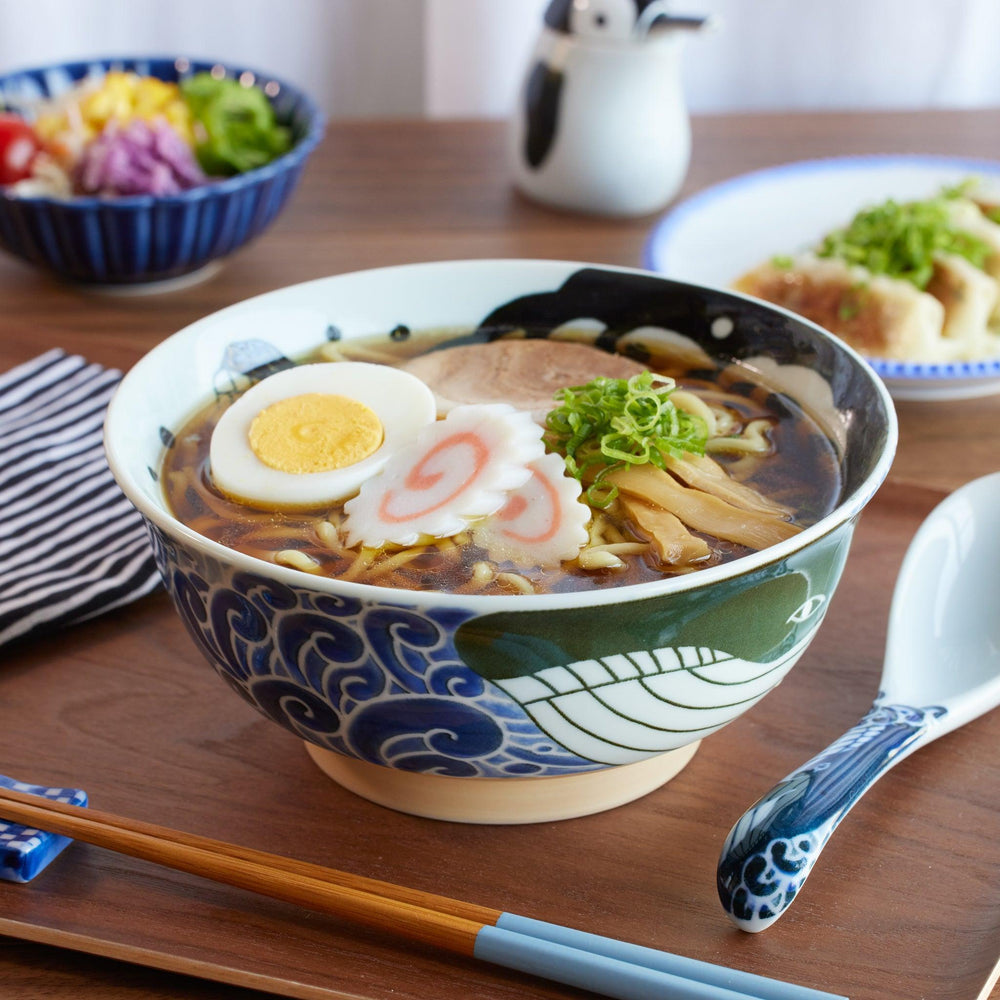 A traditional Japanese ramen bowl featuring a whale and wave design, filled with soy sauce ramen and toppings.
