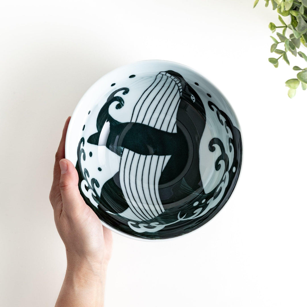 A ramen bowl with a white and blue design, featuring a whale illustration and wave patterns.