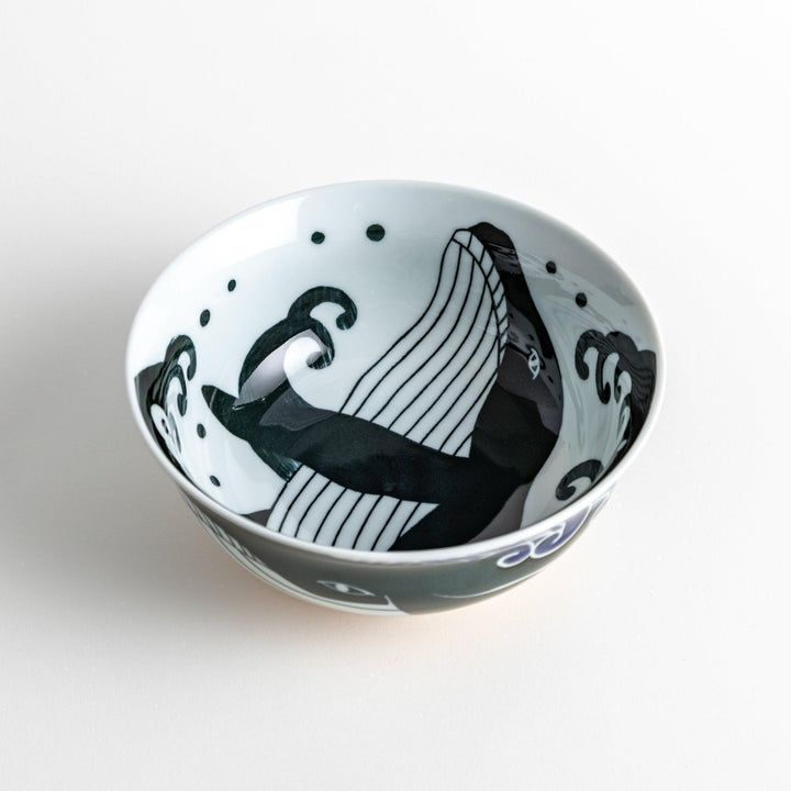 A ramen bowl with a white and blue design, featuring a whale illustration and wave patterns.