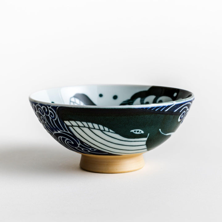 A large rice bowl with a whale and wave design in blue on a white background.