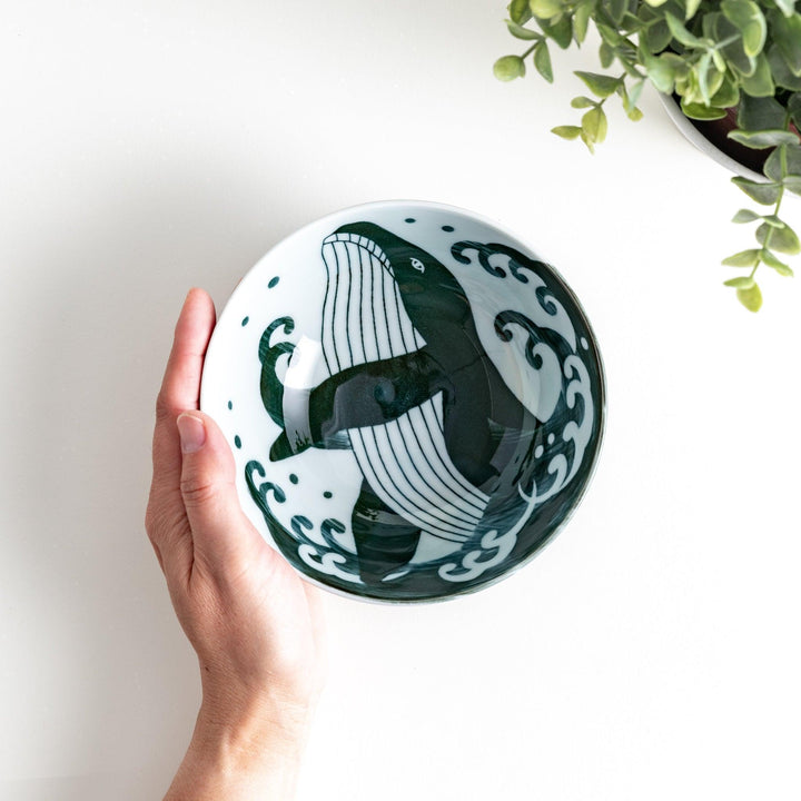 A large rice bowl with a whale and wave design in blue on a white background.