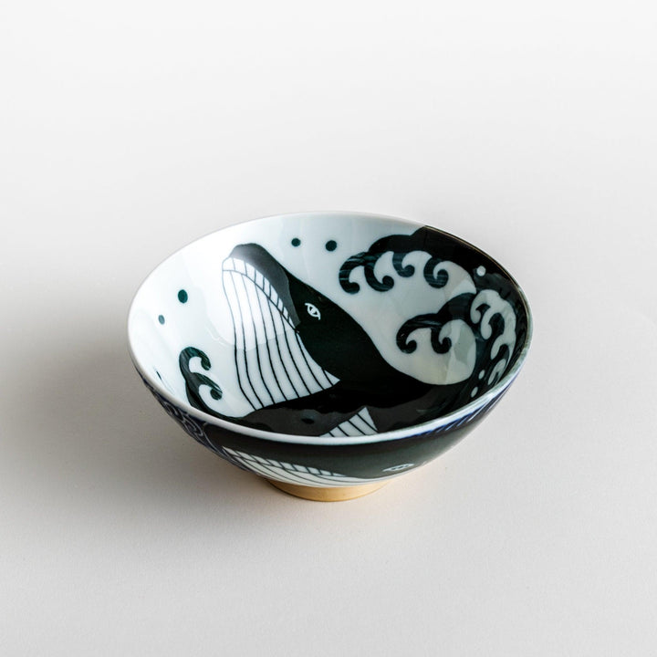 A large rice bowl with a whale and wave design in blue on a white background.
