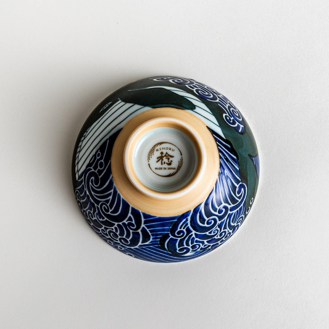 A large rice bowl with a whale and wave design in blue on a white background.