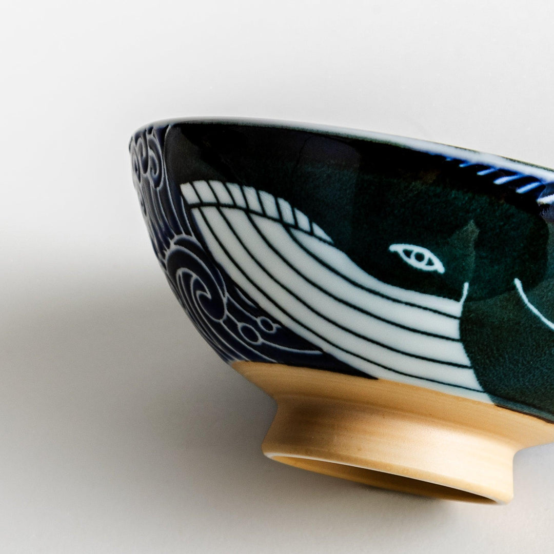 A large rice bowl with a whale and wave design in blue on a white background.