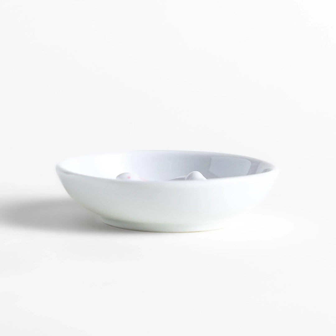 White ceramic incense holder set with round dish and rabbit holder with pink accents for charming ash collection.