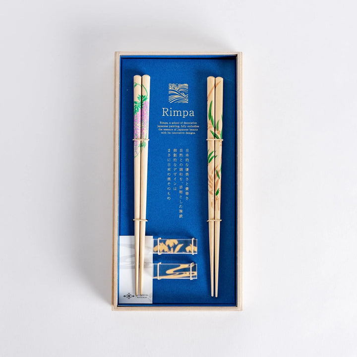 Elegant chopsticks with wisteria and bamboo motifs in wooden box with blue background for gifting.