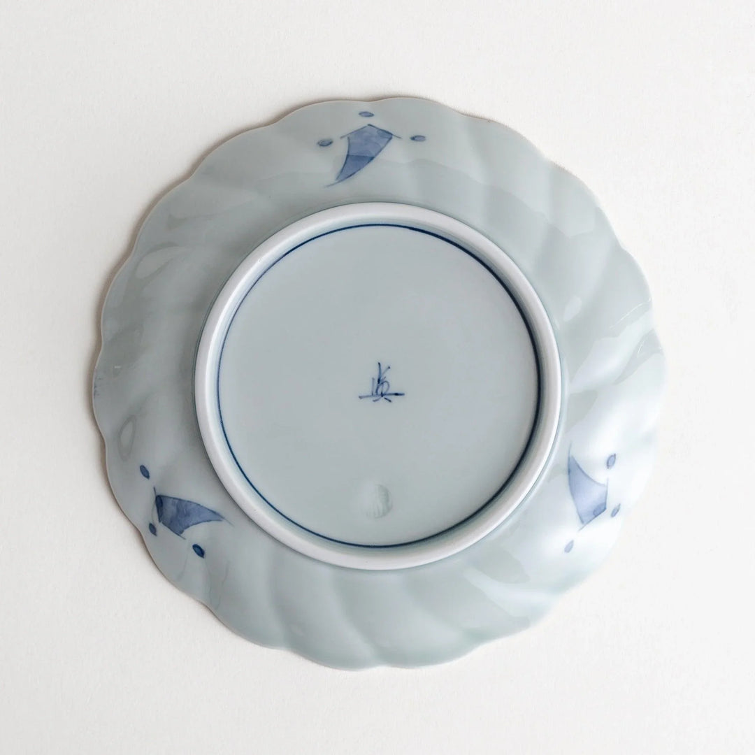 Small scalloped porcelain bowl with Imari style decoration central landscape and red blue rim motifs.