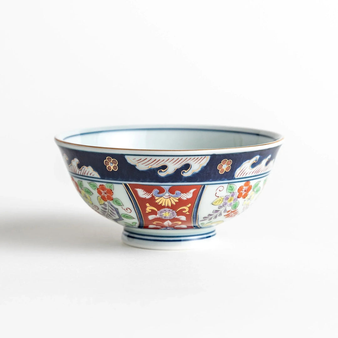 Porcelain bowl with traditional Japanese floral and geometric motifs in blue red and green with gold accents.