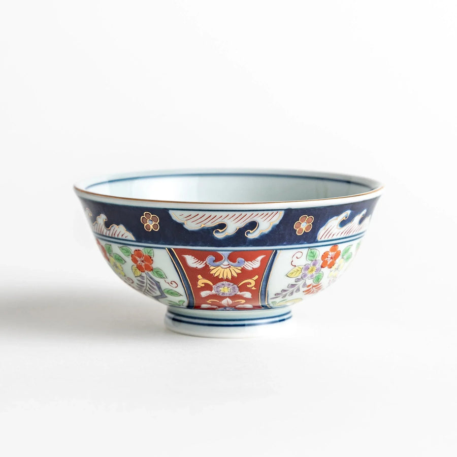 Porcelain bowl with traditional Japanese floral and geometric motifs in blue red and green with gold accents.